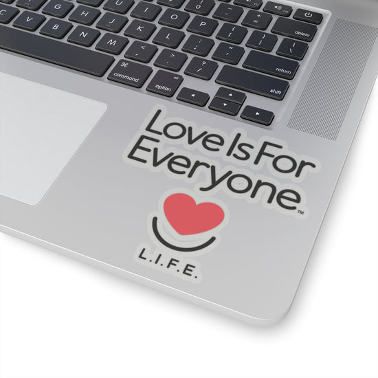 Transparent L.I.F.E. 4x4 "love is for Everyone" vinyl sticker on laptop corner with heart smile logo.