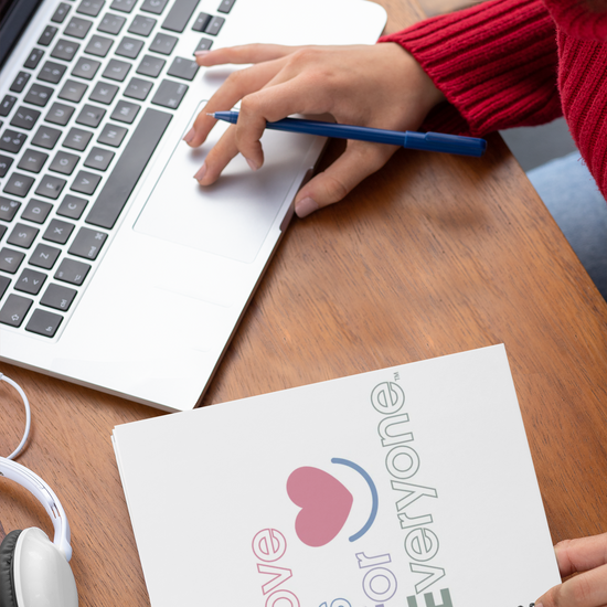 Person working on laptop with Color Pop Spiral 6x8 notebook.