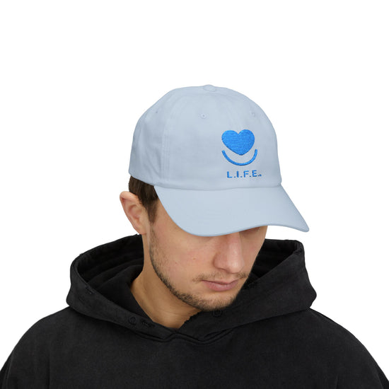 Man wearing light blue L.I.F.E. tonal dad hat with curved visor.