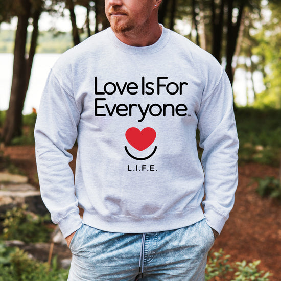 Man wearing men's Classic Crewneck sweatshirt in grey, front view with signature L.I.F.E. artwork