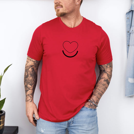 Man wearing men's Signature Tee in red, front view of smiling heart graphic.