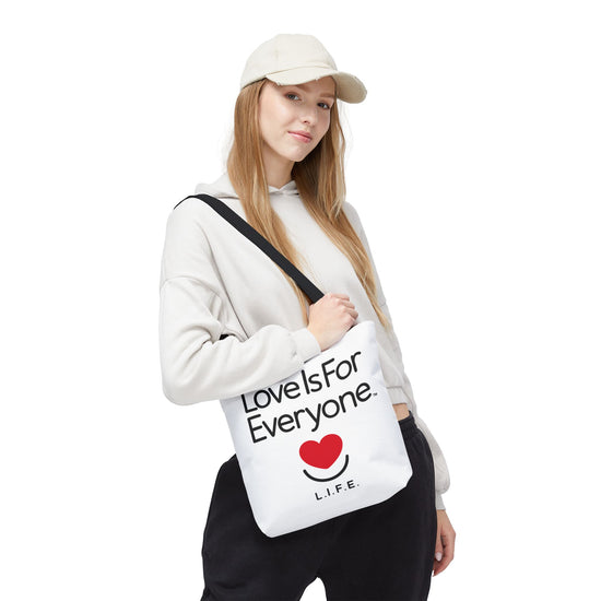 Woman wearing L.I.F.E. "Love is for Everyone" Signature tote with heart smile print.