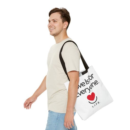 Man walking with L.I.F.E. Signature canvas tote over shoulder, casual outfit.