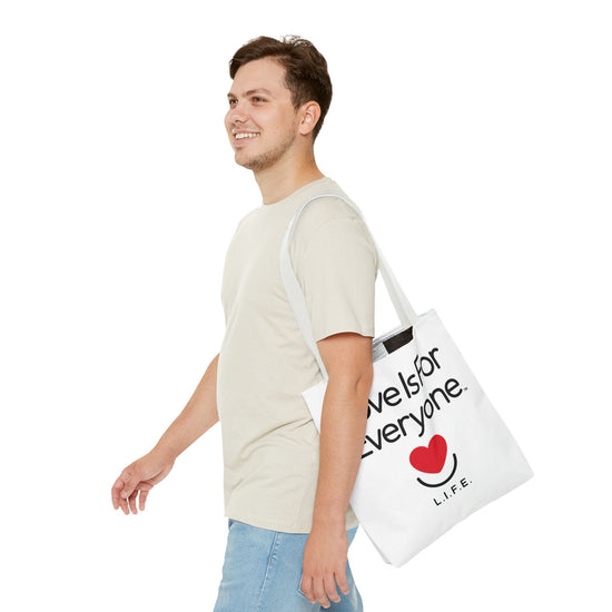 Man walking with Signature L.I.F.E. canvas tote over shoulder, casual outfit.