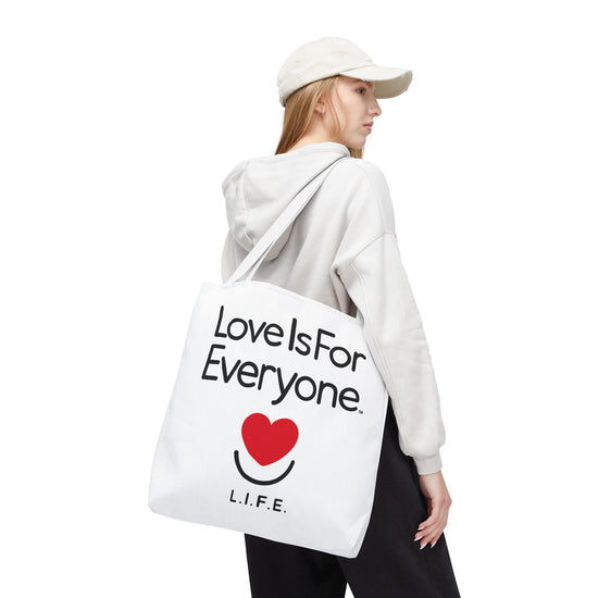 Woman with white Signature L.I.F.E. canvas tote over shoulder, reinforced white handles.