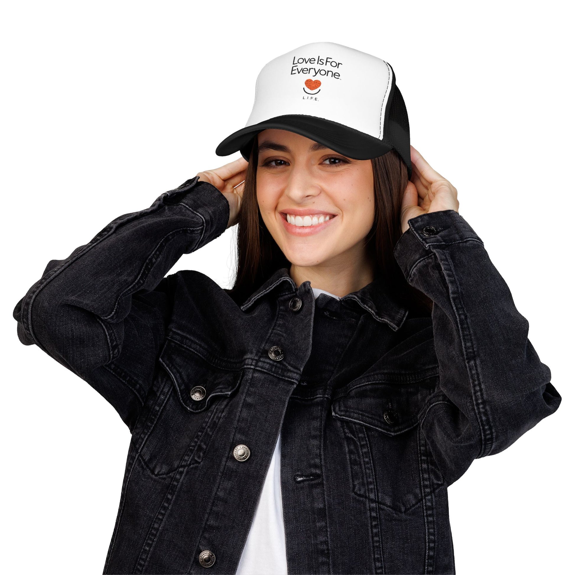 Woman wearing black and white L.I.F.E. embroidered "Love is for Everyone" trucker hat.
