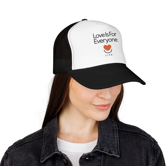 Side view of the black and white L.I.F.E. trucker hat showing the structured bill and crown.