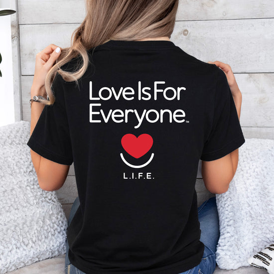 Back of black L.I.F.E. Signature Tee showing "Love is for Everyone" mission message.