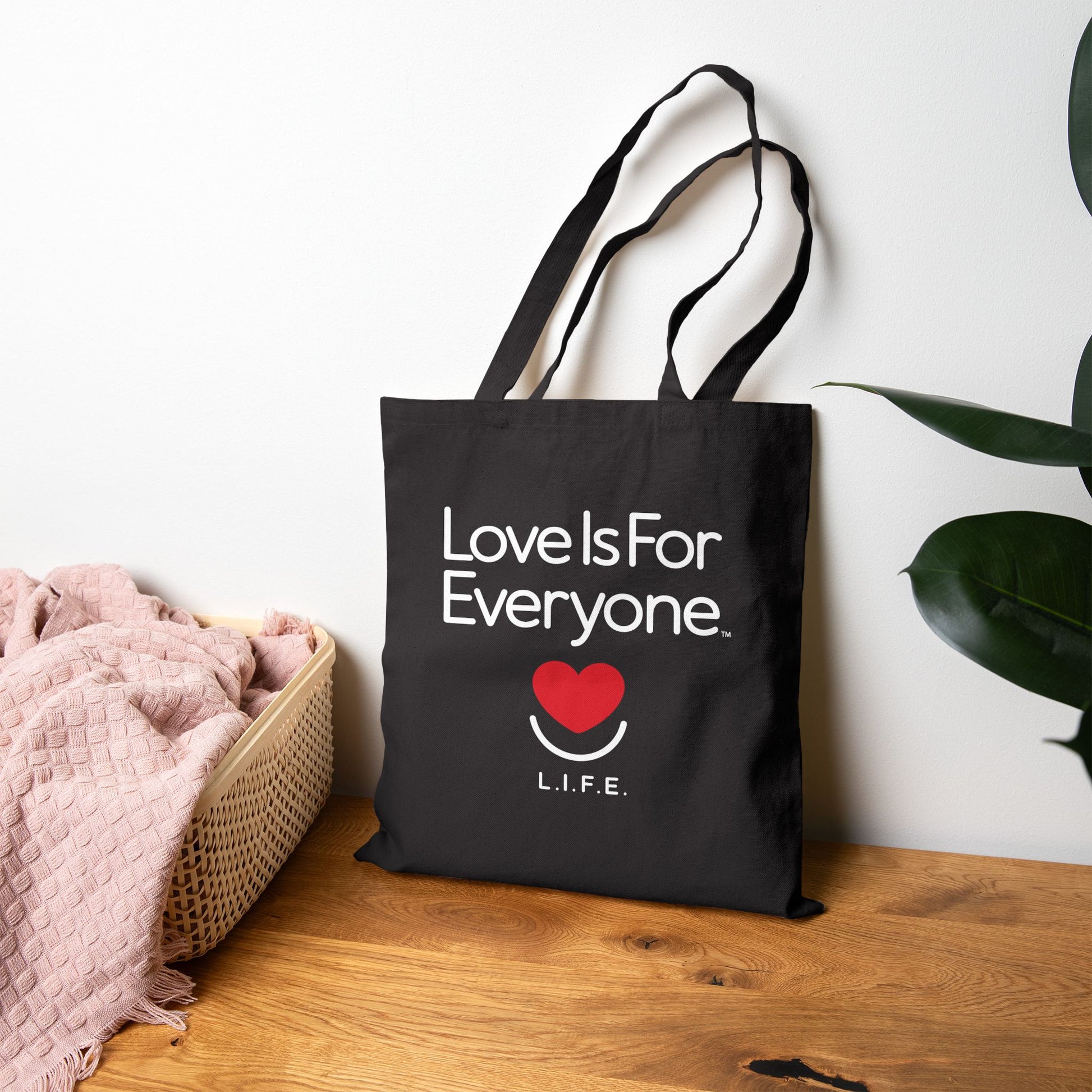 Black Everyday L.I.F.E. canvas tote on tabletop showing flat corners and reinforced handles. 