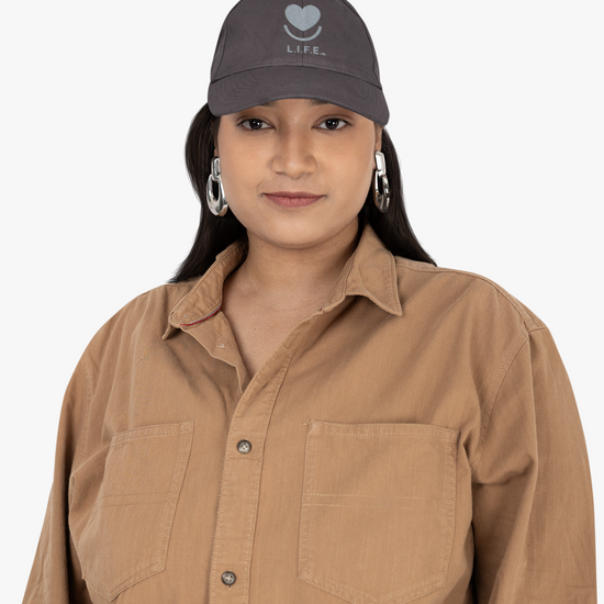 Woman wearing dark grey L.I.F.E.tonal dad hat styled with oversized shirt. 