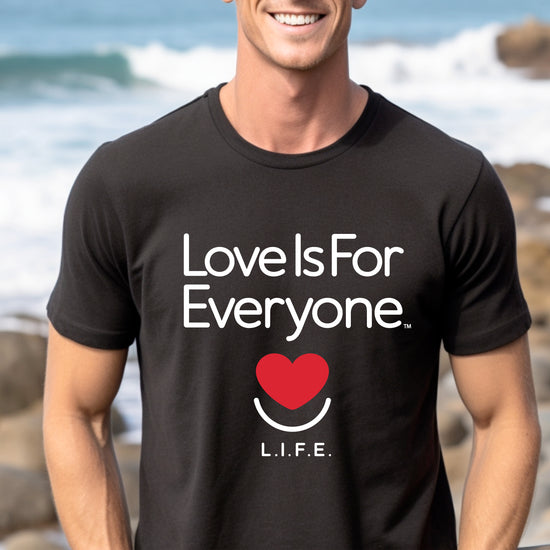 Man wearing men's black Classic Tee, front view with smiling heart logo and L.I.F.E. message. 