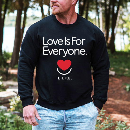 Man wearing men's Classic Crewneck sweatshirt in black, front view with signature L.I.F.E. artwork. 