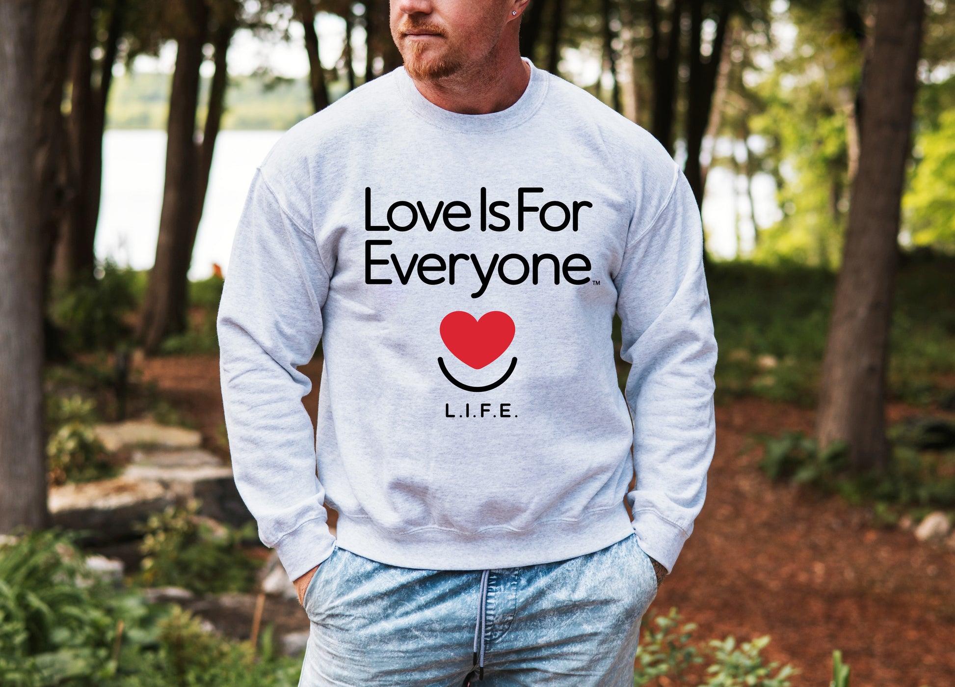 Man wearing men's Classic Crewneck sweatshirt in grey, front view with signature L.I.F.E. artwork