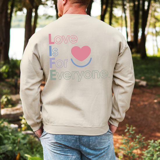 Man wearing men's Color Pop sand crewneck, back view vertical L.I.F.E. statement message. 