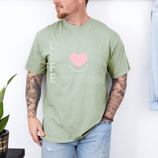 Man wearing Bay Colorful Expressions Tee with “Love is for Everyone” vertical heart message 