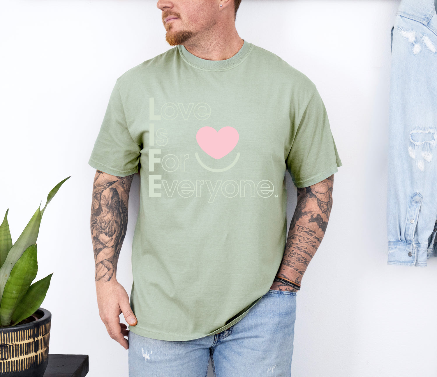 Man wearing Bay Colorful Expressions Tee with “Love is for Everyone” vertical heart message 