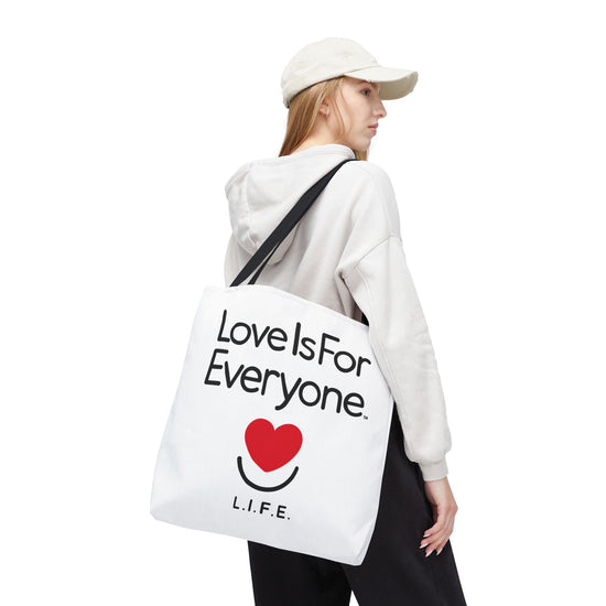 Woman walking with 18'x18" Signature L.I.F.E. tote bag white with black contrast handles. 