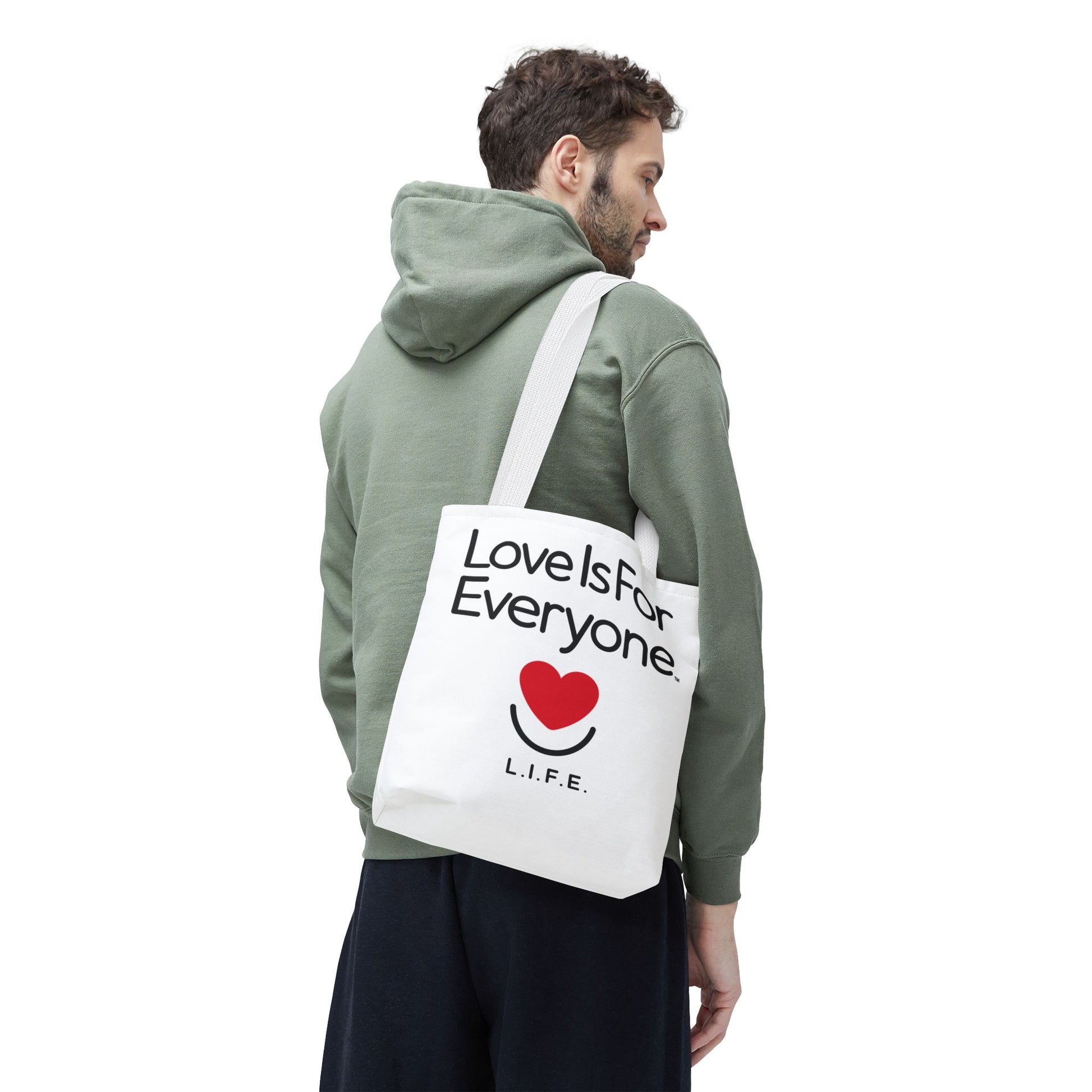 Man carrying white L.I.F.E. Signature canvas tote with heart print and message with white handles. 