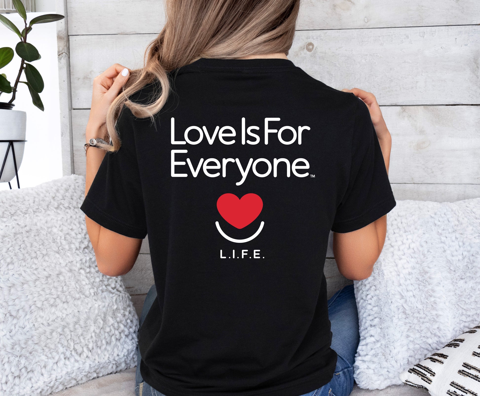 Back of black L.I.F.E. Signature Tee showing "Love is for Everyone" mission message. 