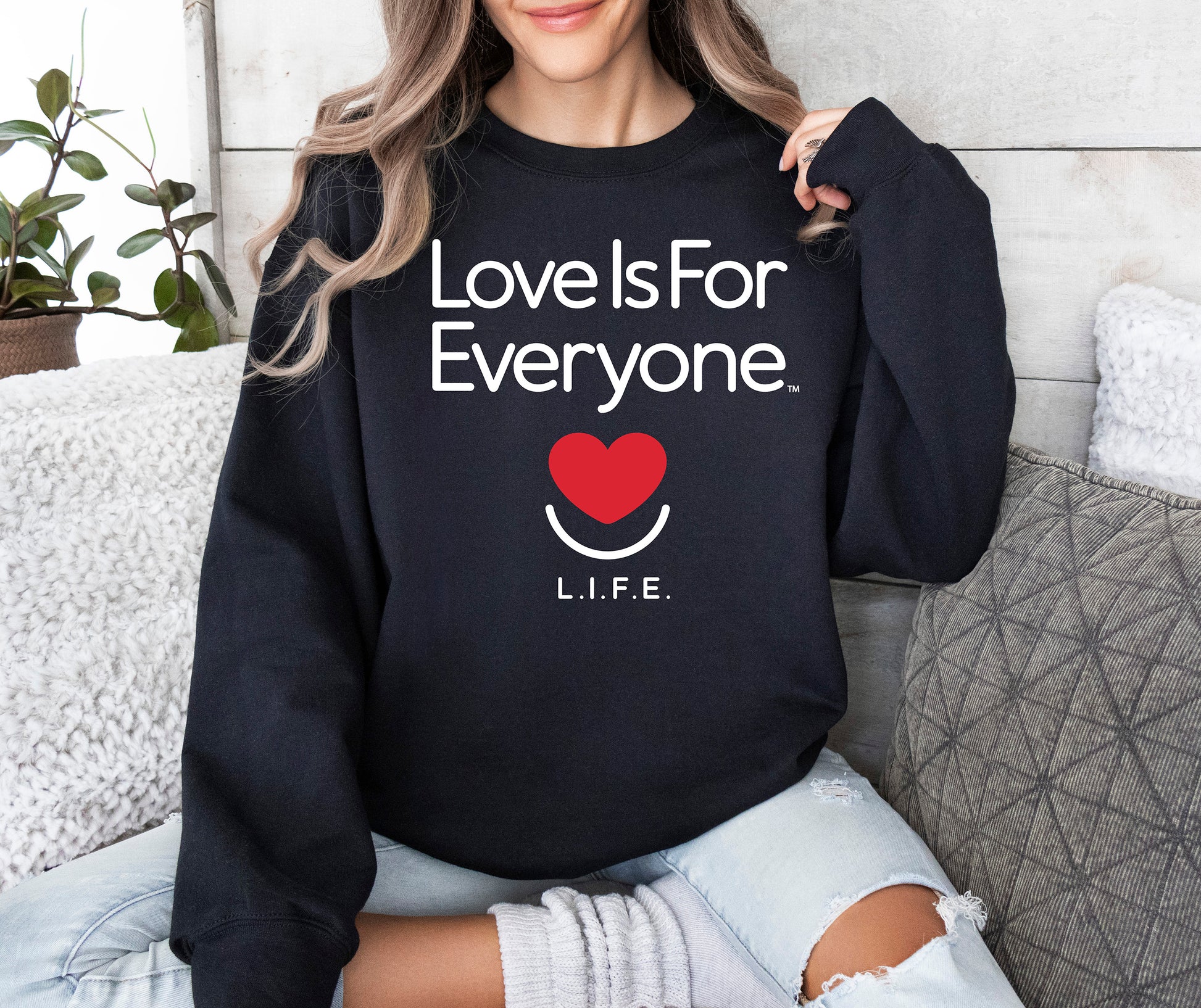 Woman wearing women's Classic Crewneck in black, front view with L.I.F.E. signature graphic.