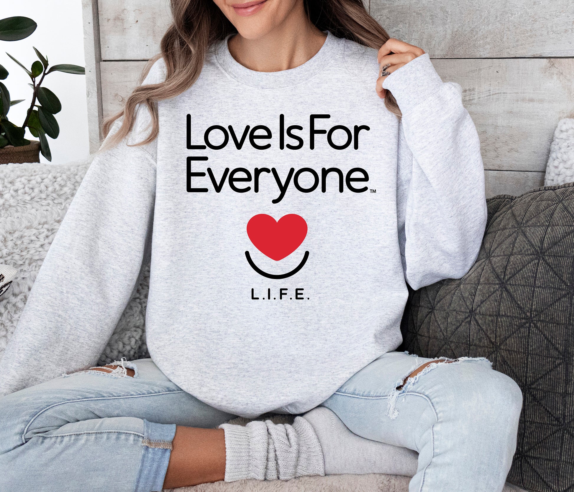 Woman wearing women's Classic Crewneck in grey, front view with L.I.F.E. signature graphic. 