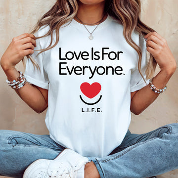Woman wearing the women's Classic Tee, white, front view with "Love is for Everyone" core design with smiling heart. 
