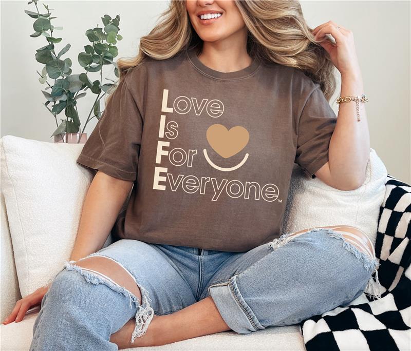 Woman wearing Espresso Comfort Colors®  tshirt with tonal "Love is for Everyone" heart design message.  