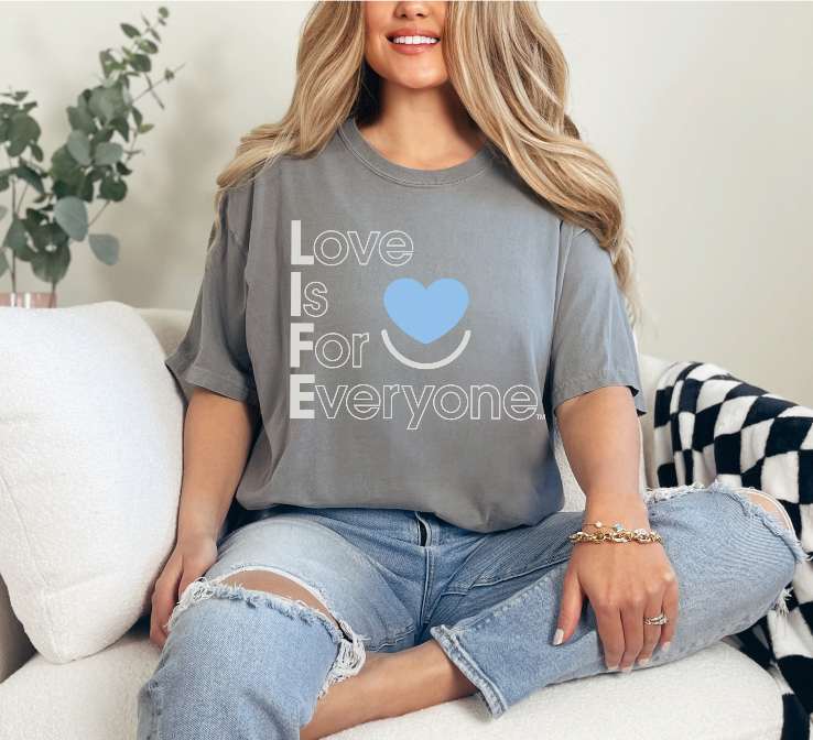 Woman wearing grey Comfort Colors® T-shirt with positive "Love is for Everyone" message.  