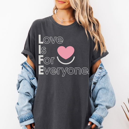 Woman wearing Comfort Colors® Tshirt with positive message "Love is for Everyone" heart design. 