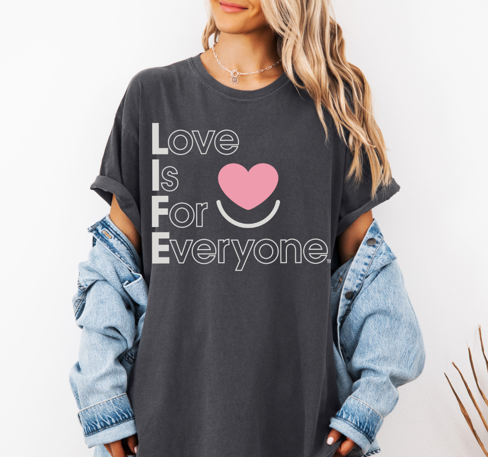 Woman wearing Comfort Colors® Tshirt with positive message "Love is for Everyone" heart design. 