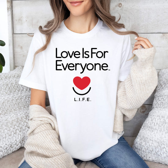 Woman wearing L.I.F.E. "Love is for Everyone" Classic women's graphic T-shirt in white with smiling heart logo. 